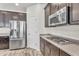 A kitchen featuring stainless steel refrigerator and appliances, dark cabinets, and a gas cooktop stove at 2592 E Torrey Pines Ln, Chandler, AZ 85249