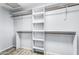 Bright walk-in closet featuring built-in shelving and hanging rods for optimal organization and storage at 2592 E Torrey Pines Ln, Chandler, AZ 85249