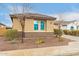 Tan house with matching accents, tiled roof, a lawn of rock and some shrubbery at 25955 W Deer Valley Rd, Buckeye, AZ 85396