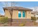 Tan house with matching accents, tiled roof, a lawn of rock and some shrubbery at 25955 W Deer Valley Rd, Buckeye, AZ 85396