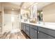 Elegant bathroom with double sinks, gray cabinets, a glass-enclosed shower, and stylish fixtures at 25955 W Deer Valley Rd, Buckeye, AZ 85396