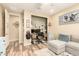 Versatile room featuring a stylish gray couch, home office nook, and natural-toned wood flooring at 25955 W Deer Valley Rd, Buckeye, AZ 85396