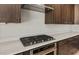 Close up of stainless steel gas stove, oven and dark cabinets with white countertops at 26657 W Renee Dr, Buckeye, AZ 85396