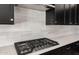 A close-up of the kitchen with an overhead vent, white countertops, stainless steel appliances, and black cabinetry at 26817 W Renee Dr, Buckeye, AZ 85396