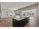 A kitchen island features a sink, white countertops, and dark cabinets, perfect for food prep and casual dining at 26817 W Renee Dr, Buckeye, AZ 85396