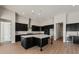 This kitchen features an island with a sink, stainless appliances and black cabinetry at 26817 W Renee Dr, Buckeye, AZ 85396