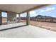 An exterior shot of the patio featuring a fireplace with stone pillars and a view of the surrounding landscape at 26817 W Renee Dr, Buckeye, AZ 85396