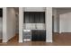 An interior shot of the wet bar featuring sleek black cabinetry and stainless-steel beverage refrigerator at 26817 W Renee Dr, Buckeye, AZ 85396