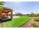 Spacious backyard featuring a covered patio, a built-in pool, and artificial grass landscaping at 30804 N 120Th Ave, Peoria, AZ 85383