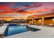 Amazing backyard featuring a pool with water feature, fire pit, desert landscaping, and covered patio at 30804 N 120Th Ave, Peoria, AZ 85383