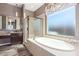 Luxurious bathroom featuring a soaking tub, glass-enclosed shower, and a granite vanity at 30804 N 120Th Ave, Peoria, AZ 85383