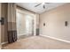 This is a carpeted bedroom with neutral colors, a ceiling fan, and an open door at 30804 N 120Th Ave, Peoria, AZ 85383