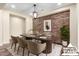 Elegant dining room features a stone accent wall, stylish lighting, and a modern table setting for sophisticated gatherings at 30804 N 120Th Ave, Peoria, AZ 85383