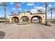 Beautiful community entrance with archways, American flag, landscaping, and brick-paved road at 30804 N 120Th Ave, Peoria, AZ 85383