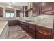 Spacious kitchen with stainless steel appliances, granite countertops, dark wood cabinets, and tile backsplash at 30804 N 120Th Ave, Peoria, AZ 85383