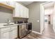 This laundry room features wooden-look floors, washer/dryer, and cabinets at 30804 N 120Th Ave, Peoria, AZ 85383