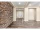 Open living area featuring a stone accent wall and wood-look tile flooring at 30804 N 120Th Ave, Peoria, AZ 85383