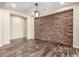 Open living room with stone accent wall, modern lighting, and wood-look tile flooring at 30804 N 120Th Ave, Peoria, AZ 85383