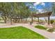 Relaxing outdoor seating area with pergola, tables, and lush green grass at 30804 N 120Th Ave, Peoria, AZ 85383