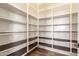 Walk-in pantry with ample shelving and dark vinyl flooring at 30804 N 120Th Ave, Peoria, AZ 85383