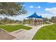 Community playground area with shade structure, play equipment, walking paths, and a bike rack at 30804 N 120Th Ave, Peoria, AZ 85383