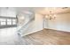 Spacious living room with wood flooring, a staircase, neutral paint, and a modern chandelier at 3115 W Molly Ln, Phoenix, AZ 85083