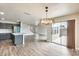 Living room with kitchen access, wood floors, and sliding glass doors at 3115 W Molly Ln, Phoenix, AZ 85083