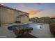 Private backyard pool with rock feature and desert landscaping in a two story single Gathering home at sunset at 3115 W Molly Ln, Phoenix, AZ 85083