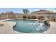 Beautiful backyard pool with rock waterfall feature, surrounded by desert landscaping and concrete trim at 3115 W Molly Ln, Phoenix, AZ 85083