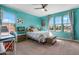 A light and airy bedroom with a ceiling fan, large window, and colorful decor at 3322 E Lantana Pl, Chandler, AZ 85286