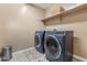 Modern laundry room featuring a pair of front-loading blue washing machines with an open shelf at 3322 E Lantana Pl, Chandler, AZ 85286