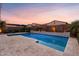 Beautiful backyard pool with travertine tile decking and lush landscaping at dusk at 3322 E Lantana Pl, Chandler, AZ 85286