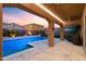 Covered patio overlooks the pool featuring desert landscaping and spacious travertine tiled deck at 3322 E Lantana Pl, Chandler, AZ 85286