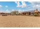 Vast backyard with desert landscaping, a covered patio, and a neighboring building in the distance at 35207 N Central Ave, Phoenix, AZ 85086