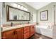 Bathroom with double sink vanity, tiled floors, a large mirror, and a separate tub and shower at 35207 N Central Ave, Phoenix, AZ 85086