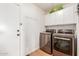 A laundry room with stainless steel LG front-loading machines and overhead storage at 35207 N Central Ave, Phoenix, AZ 85086