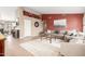 Open-concept living room with red accent wall, decorative shelving, and tile flooring throughout at 35207 N Central Ave, Phoenix, AZ 85086