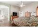 Well-lit main bedroom featuring a ceiling fan, ensuite bathroom, and wooden floors at 35207 N Central Ave, Phoenix, AZ 85086