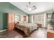 The main bedroom features a ceiling fan, wood floors, and large windows at 35207 N Central Ave, Phoenix, AZ 85086