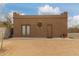 Exterior view of outbuilding featuring double doors, a single entry door, stucco walls, and concrete pad at 35207 N Central Ave, Phoenix, AZ 85086