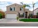 Two-story home with well-manicured front yard, palm trees, and a two-car garage at 3581 W Mineral Butte Dr, San Tan Valley, AZ 85144