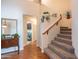 Hallway with a staircase, a vintage table with decor, and a view into the laundry room at 3581 W Mineral Butte Dr, San Tan Valley, AZ 85144