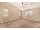 Spacious bedroom with vaulted ceiling, neutral paint and carpet, and multiple windows for plenty of natural light at 35973 W Velazquez Dr, Maricopa, AZ 85138