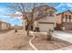 Well-maintained front yard with desert landscaping framing a charming two-story home with a two-car garage at 35973 W Velazquez Dr, Maricopa, AZ 85138