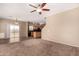 Open-concept living area with carpet, access to the backyard, and views into the adjacent kitchen at 35973 W Velazquez Dr, Maricopa, AZ 85138