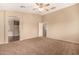 Bright bedroom with ceiling fan, carpet and ensuite bath featuring a garden tub and separate shower at 35973 W Velazquez Dr, Maricopa, AZ 85138