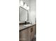 Modern powder room featuring floating vanity, stone counter, and designer mirror at 377 E Windsor Ave # 16, Phoenix, AZ 85004