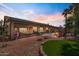 A spacious backyard with pavers, desert landscaping and artificial turf under sunset sky at 4068 N 155Th Ln, Goodyear, AZ 85395