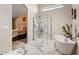 Modern bathroom with marble tile, walk-in shower, and separate soaking tub at 4068 N 155Th Ln, Goodyear, AZ 85395