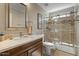 Bathroom with wood vanity, marble countertop, glass shower and decorative tile at 4068 N 155Th Ln, Goodyear, AZ 85395